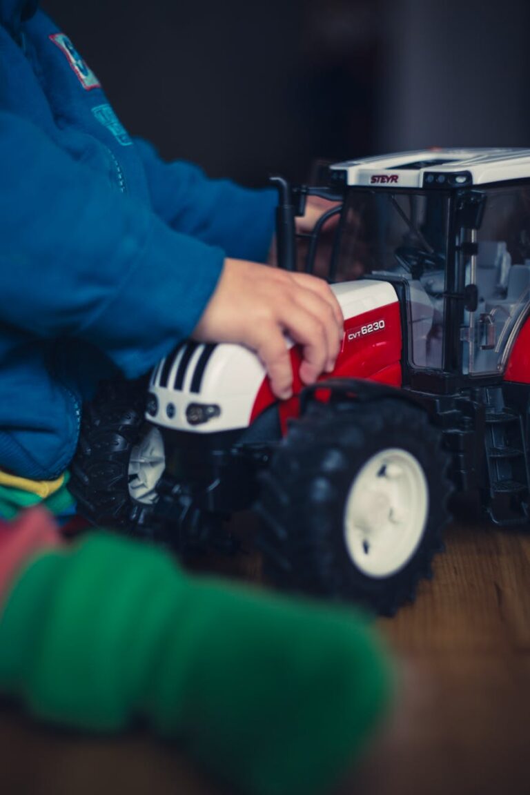 Top 10 Best Tractor Brand? A Complete Guide for 2025 3 person in blue jacket holding red and white tractor toy